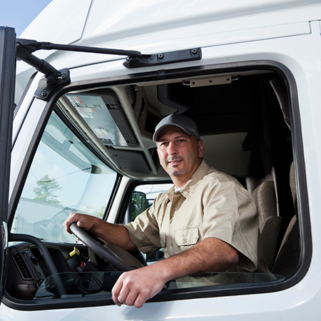 Blond lady looking at papers with a driver standing by a truck